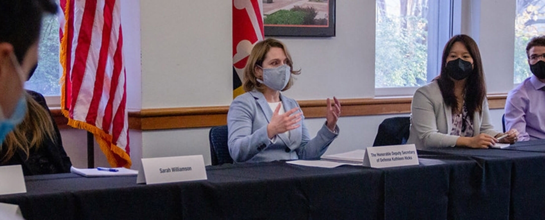 Deputy Secretary of Defense Kathleen Hicks sits in a classroom next to a student